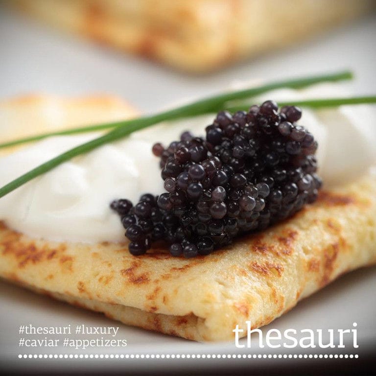 pancake with caviar eggs on top and fres green plant from 'Thesauri Caviar'