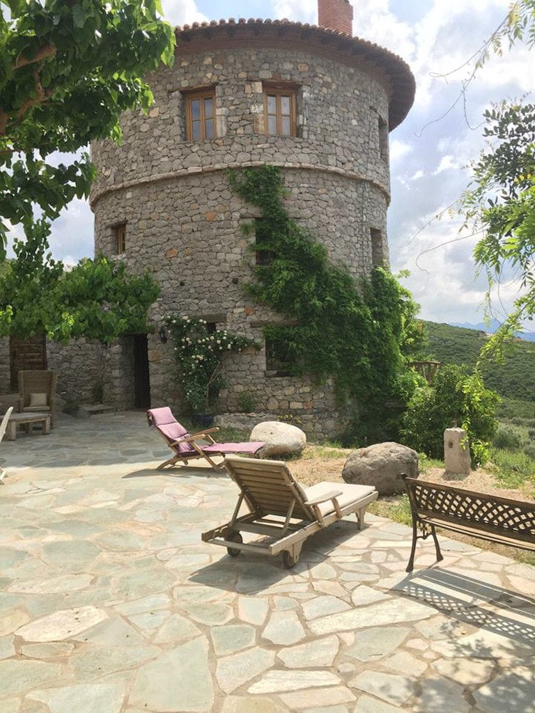 entrance of the tower 'La Tour Melas' winery with stone pavement and trees