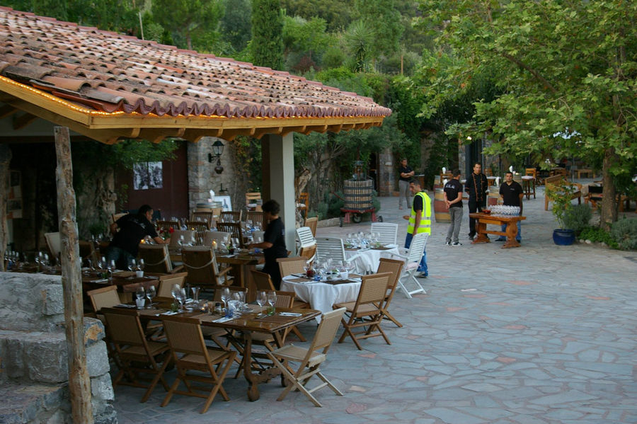 tables with chairs 'La Tour Melas' outside and tourists relaxing