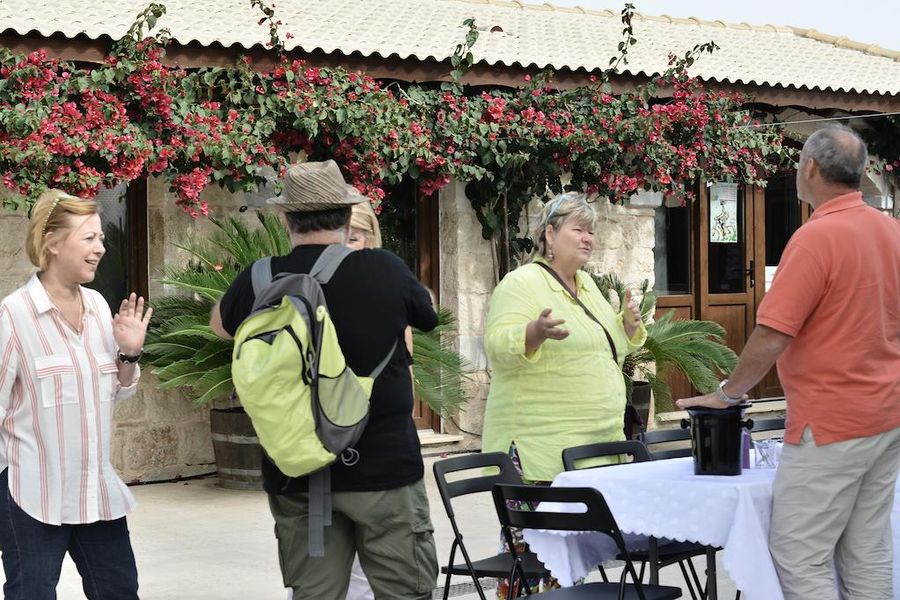 A group of tourists discussed outside at Gikas winery and tasting wines