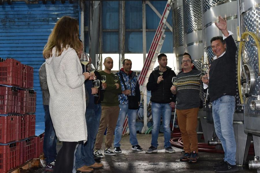 tourists listening to a woman giving a tour at Domaine Dereskos winery facilities