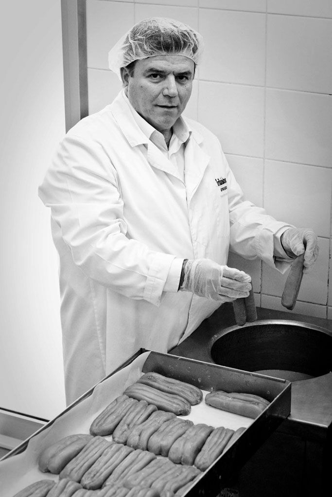 man watching at the camera and holding bottarga smoked from crate at Trikalinos plant