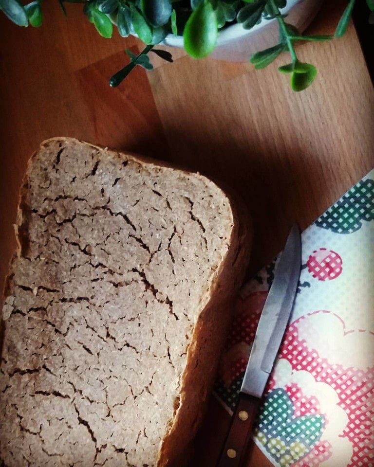 piece of wheat bread and a knife on the wood table from 'The Trinity Farm'