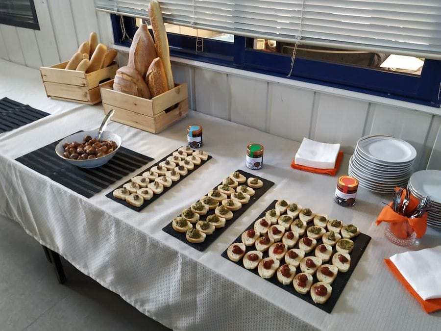 table with plateaus with various aperitifs like pieces of bread with paste snails from Feréikos