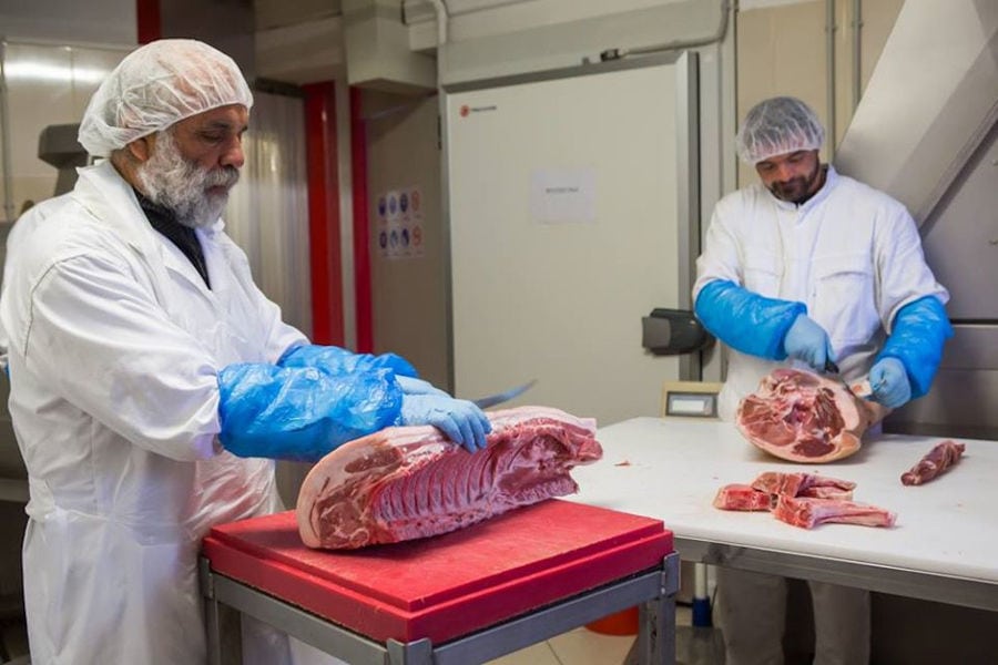 two butchers with gloves cutting meet at Vavourakis Farm workshop
