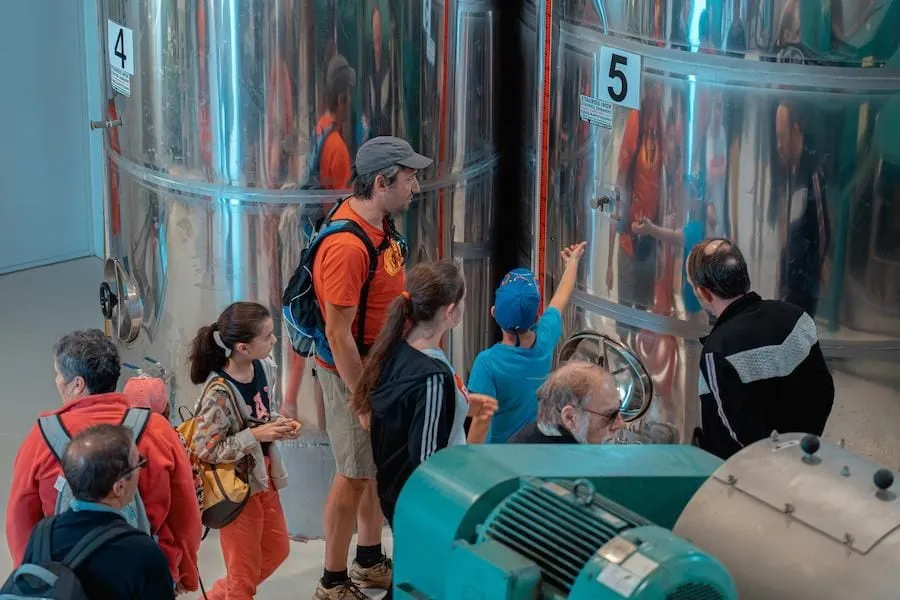 Group of visitors inside at Politakis Olive Oil Mill seeing the aluminum storage tanks