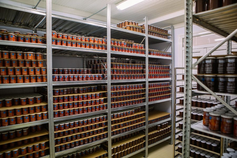 jars with various sauces on shelves on the top of each other at 'Rizes' plant
