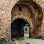 a stone archway with a brick wall