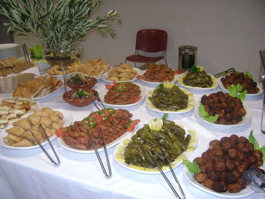 plateaus with various cooking foods like fried rolls meet at 'Agrotouristic Women's Cooperative of Mesotopos Lesvos'