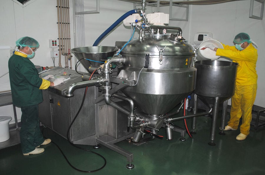 a man working at control panel of mixer machine ant another οverturning bucket with additives into mixer at 'Pitenis' plant