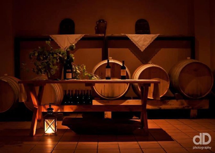 wood table and barrels on the wall of 'Aidarini Winery'