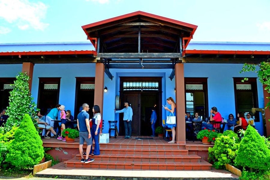 outside 'Aidarini Winery' entrance with a group of tourists waiting on the steps stairs