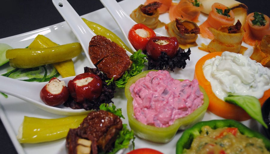 plate with various aperitifs from 'Pitenis' like stuffed peppers with salade and mayonnaise or pickles