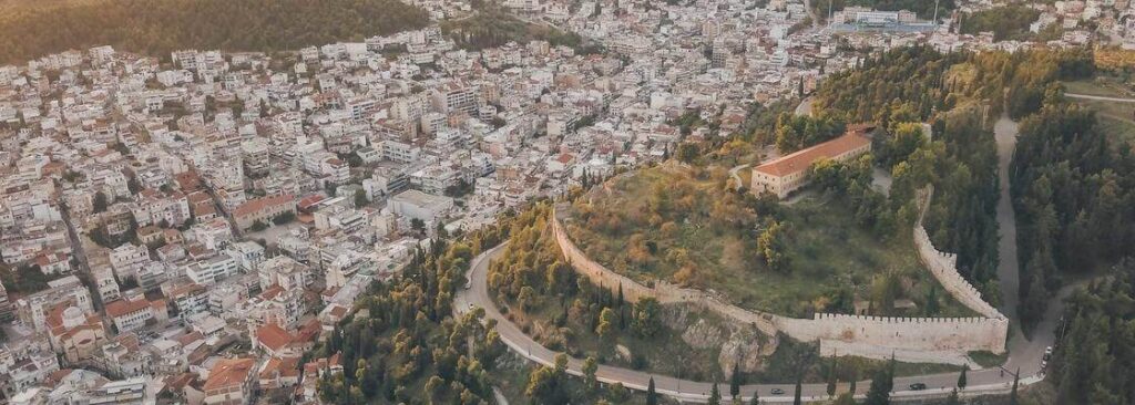 a road on a hill with trees and buildings