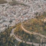 a road on a hill with trees and buildings