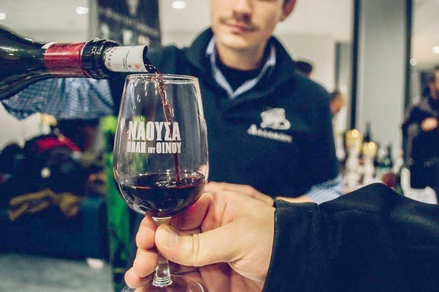 a person pouring a wine into a glass