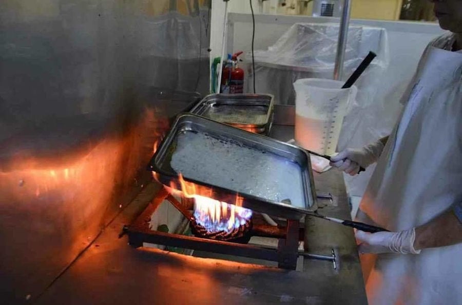 hands hold metallic form and fire heats up it at 'Bekas Family Farm' plant