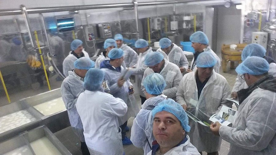 view from above of a group of tourists dressed with white forms at 'Bekas Family Farm' plant and a man taking a selfie