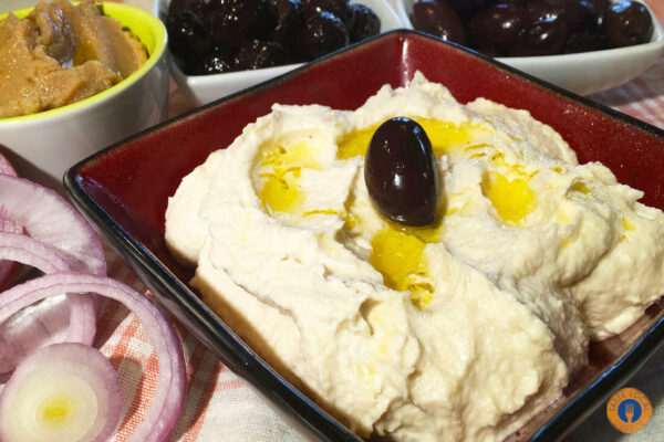 a bowl of hummus with olives