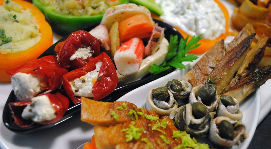 plate with various aperitifs from 'Pitenis' like stuffed pickles with salade and mayonnaise