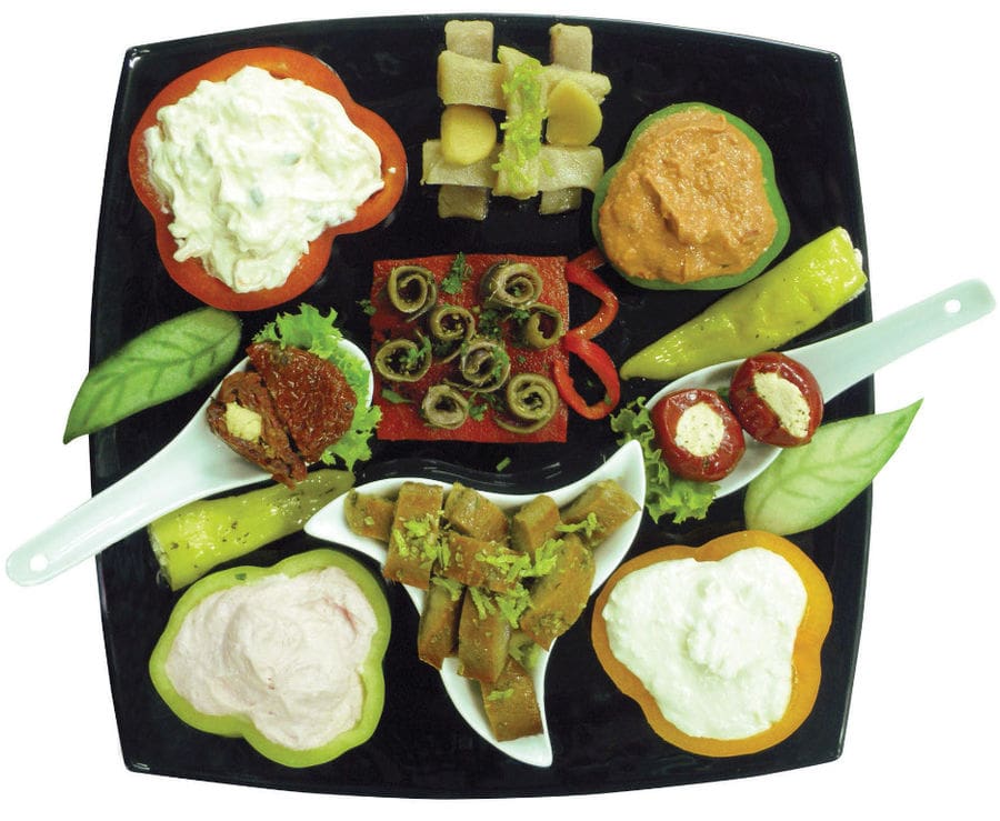 plate with various aperitifs from 'Pitenis' like stuffed peppers with salade and mayonnaise or pickles