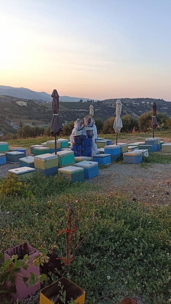 zrAI6o2J_two beekeepers and two children dressed as beekeepers between bee hives –Gastronomy Tours.jpg